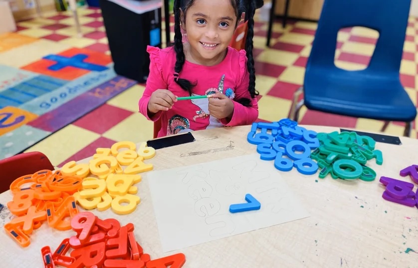 Preschool student practicing letters at Life House Child Enrichment Station